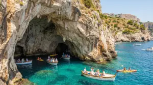 Barche turistiche davanti all'ingresso di una grotta marina su una costa rocciosa italiana